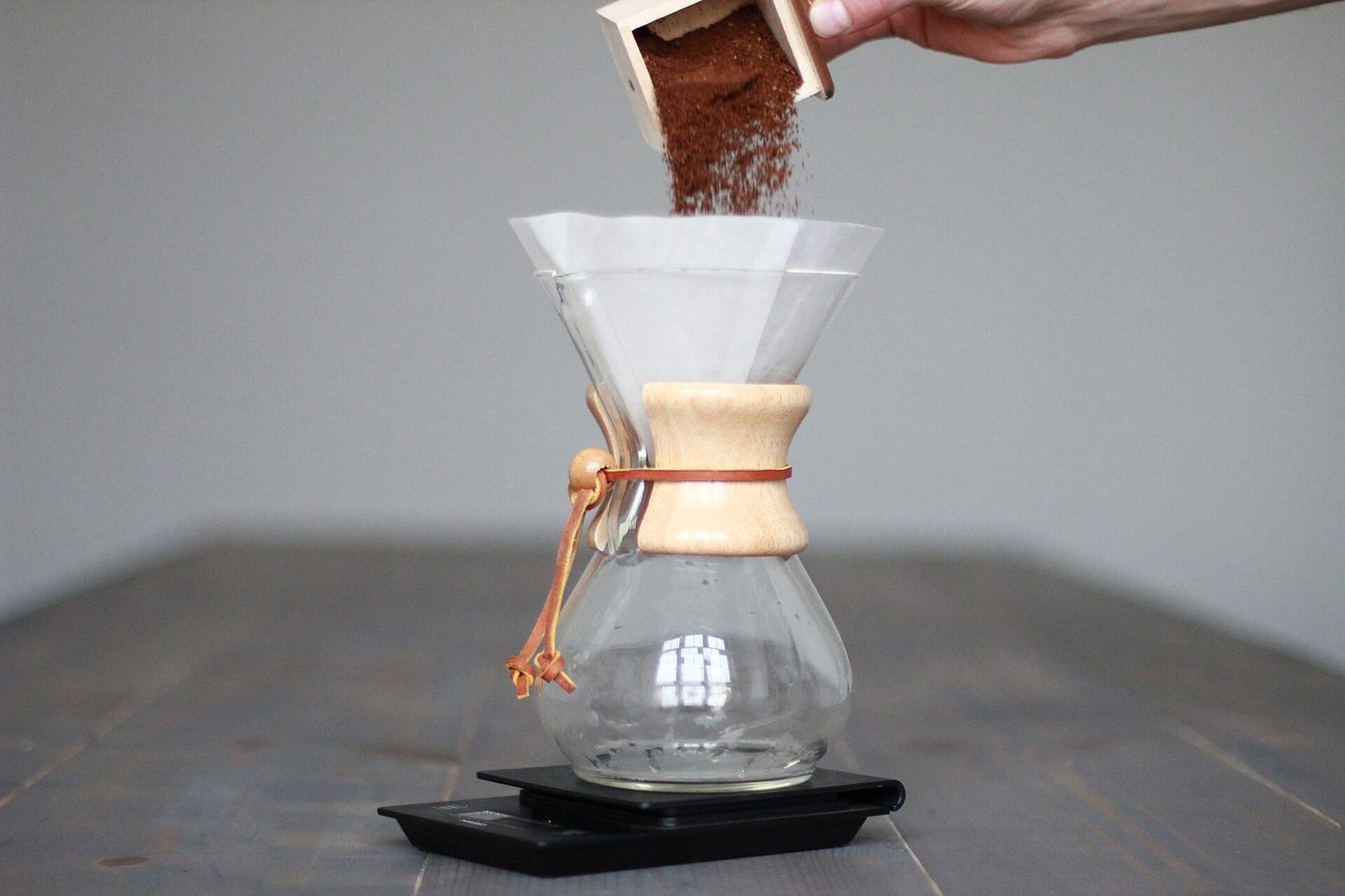Ground coffee poured into a six-cup Chemex on a scale